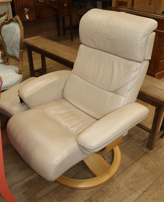 A cream leather reclining armchair and footstool